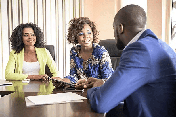 Three colleagues talking across a meeting table